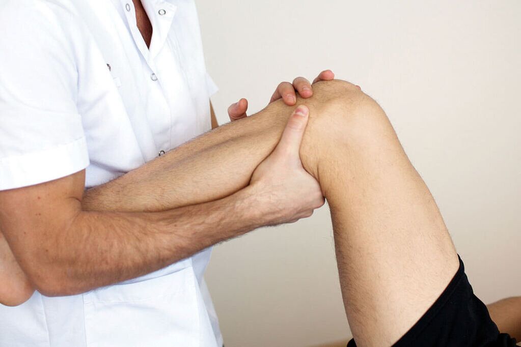 Doctor checking knee for arthritis